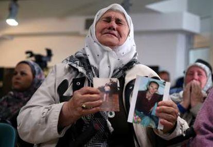 Una de las madres de Srebenica muestra unas fotos de su hijo, este miércoles en La Haya, durante el anuncio de la condena de Karadzic.