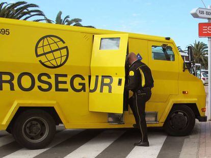 Un trabajador de Prosegur sube a una furgoneta de la empresa.