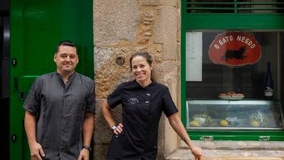 Xoan Costoya con su mujer, Veronica Moure, que también trabaja en la taberna, posan en el exterior de la tasca O Gato Negro.