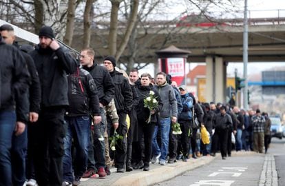 Numerosas personas aguardan con ramos de flores durante el funeral del cabecilla del grupo de hooligans HooNaRa (Hooligans-Nazis-Racistas) fallecido recientemente de cáncer, Thomas Haller, este lunes, en Chemnitz, Alemania. Las autoridades locales han dispuesto un fuerte dispositivo policial para la ceremonia.