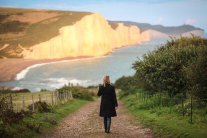 Una mujer camina hacia los acantilados de creta de Seven Sisters, en Sussex (Inglaterra).