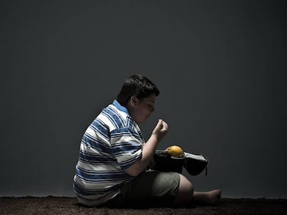 Ni&ntilde;o obeso, comiendo en la oscuridad. 