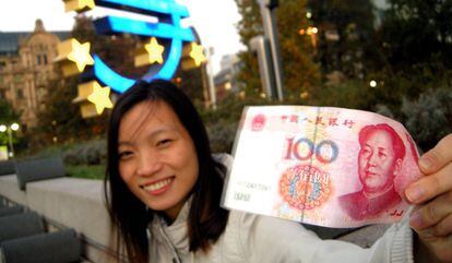 El turismo es responsable del 10% de todo el producto interior bruto del mundo, y crea uno de cada once empleos a escala global. En la foto, una turista china muestra un billete de cien yuanes frente a la sede del Banco Central Europeo, en Frankfurt.