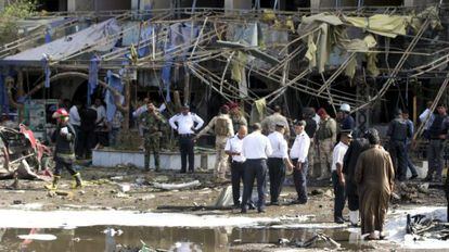 Polic&iacute;a y bomberos iraqu&iacute;es en la escena de un atentado en Bagdad.