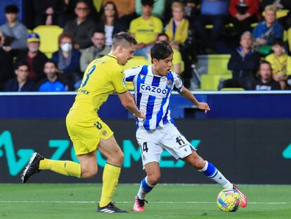 VILLARREAL, 02/04/2023.- El centrocampista japonés de la Real Sociedad, Takefusa Kubo (d), con el balón ante el defensa argentino del Villarreal, Juan Marcos Foyth, durante el encuentro correspondiente a la jornada 27 de primera división que han disputado hoy domingo en el estadio de La Cerámica, en la localidad castellonense. EFE / Domenech Castelló.
