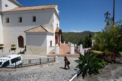 Un vecino pasea junto a la iglesia de Macharaviaya, en Málaga, pueblo sin casos positivos de coronavirus.