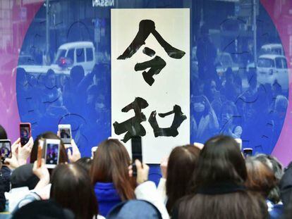 Un grupo de ciudadanos toma fotos de una pancarta con la caligrafía de la nueva era imperial, 'Reiwa' en Tokio, el pasado 1 de abril.