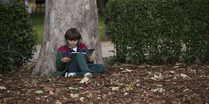 Un niño lee en la Feria del Libro de Madrid.