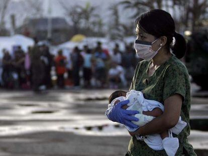 Una enfermera lleva en brazos a un bebé de siete días para evacuarlo 