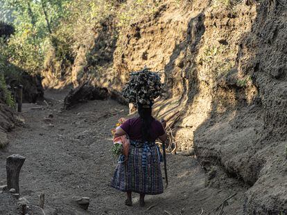 Una mujer lleva un leña sobre su cabeza en Guatemala.