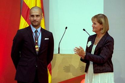 Josep Guardiola, con la medalla de oro del Parlament de Cataluña junto a Nuria de Gispert.