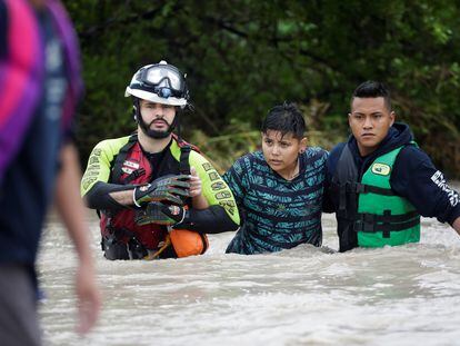 Civil protection workers rescue a youth in the aftermath of Storm Hanna in El Carmen, on the outskirts of Monterrey, Mexico July 27, 2020. REUTERS/Daniel Becerril