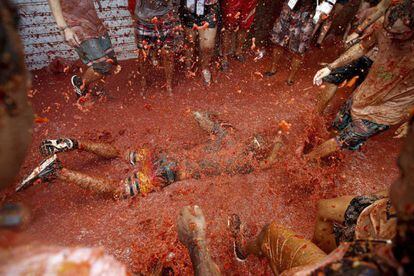 Participante en la fiesta La Tomatina en 2016, tendido en el suelo.