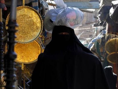 Una mujer con burka hace la compra en un mercado. 