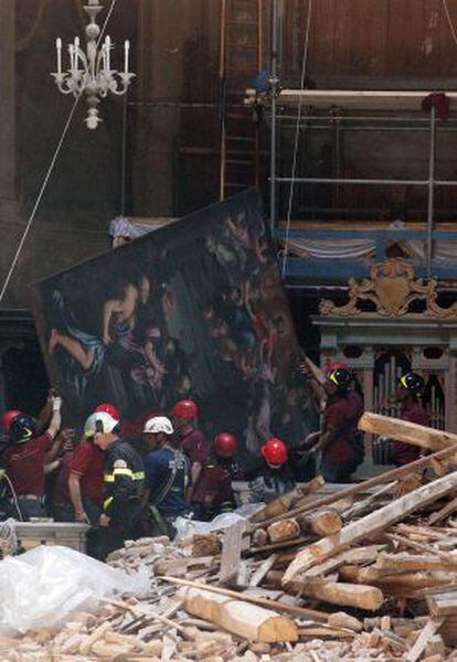 Un grupo de bomberos transporta el cuadro de Guido Reni 'L'assunzione della Vergine', recuperado de la iglesia 'Collegiata di Santa Maria Maggiore'.