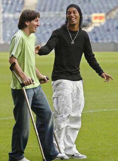 Ronaldinho conversa con el lesionado Messi.
