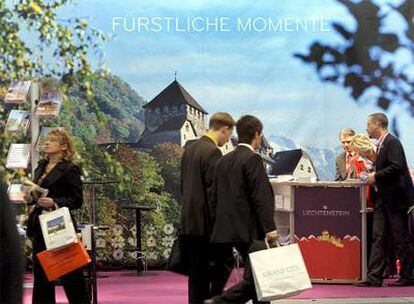 Dos personas se acercan al mostrador de Liechtenstein en una feria de turismo inaugurada ayer en Berlín.