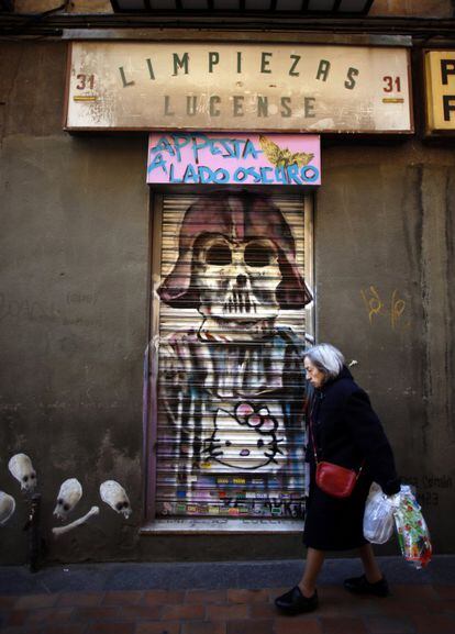 Antigua tienda de limpieza en la calle de la Madera. En la fachada, a la izquierda, un grafiti de la serie 'Fosas comunes: contra la impunidad de los crímenes franquistas'.