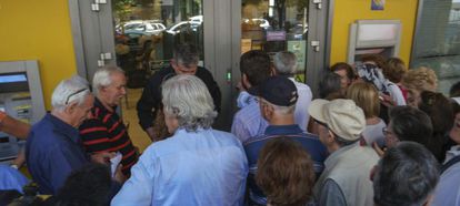 Pensionistas hacen cola para retirar dinero a la entrada de una sucursal bancaria en Sal&oacute;nica, Grecia.