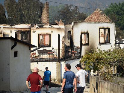 Los aldeanos observan las casas quemadas tras un incendio forestal en A Veiga de Cascalla (Orense), el 19 de julio de 2022.