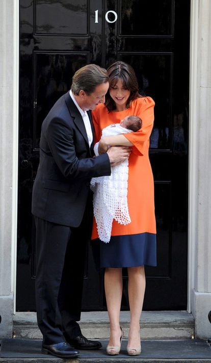 David Cameron besa a su hija, en brazos de la madre, Samantha, durante la presentación a los medios.