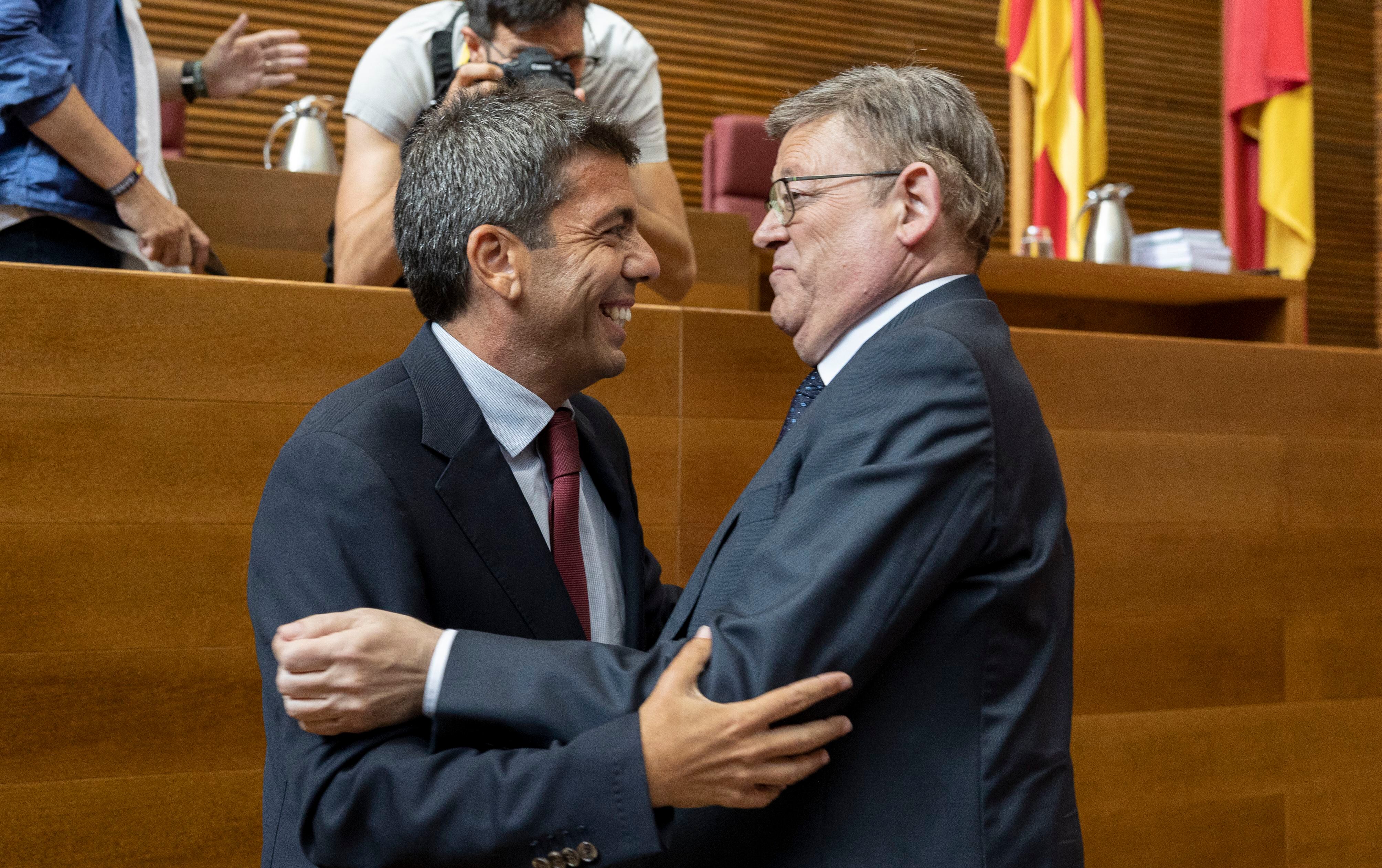 El presidente en funciones, Ximo Puig y el futuro presidente de la Generalitat, Carlos Mazón (izquierda) se saludan al inicio del pleno de  constitución del nuevo parlamento autonómico.