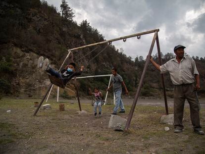 Francisco Castro juega con sus hijos en la ladera del volcán Popocatépetl en Xalitzintla, Puebla.