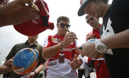 Alonso firma cascos de Renault, en Sepang.