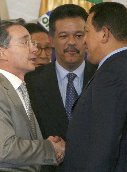 Hugo Chávez y Álvaro Uribe se dan la mano ante la mirada del presidente dominicano, Leonel Fernández.