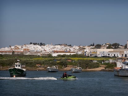 Una moto de agua y unos barcos de pesca navegan en la desembocadura del Guadiana, en Ayamonte, una de las zonas de Huelva en las que crece el tráfico de hachís por la presión en el Estrecho de Gibraltar