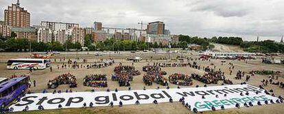 Protesta organizada ayer por Greenpeace en el puerto de Rostock, en la que un cartel gigante pide que se detenga el calentamiento global.