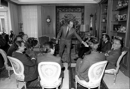 El rey Juan Carlos I recibe a los líderes de los partidos parlamentarios. De izquierda a derecha, Xabier Arzalluz, Manuel Fraga, Landelino Lavilla, Adolfo Suárez, Felipe González, Santiago Carrillo (al que el Rey entrega un cenicero), Miquel Roca y Leopoldo Calvo-Sotelo en la jornada de reflexión de las elecciones legislativas.