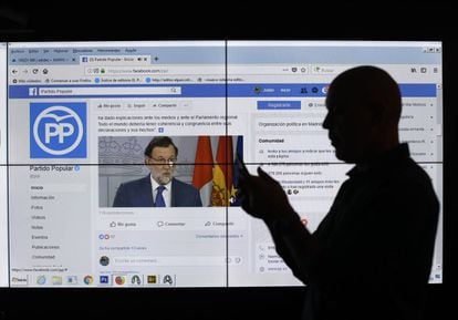 Un hombre frente a una pantalla con la página de Facebook del Partido Popular.
