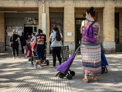 Un grupo de mujeres espera su turno en un local del Banco de Alimentos en el barrio de Orcasitas, Madrid.