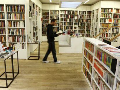 Un hombre camina mientras lee un libro en la librería Juan Rulfo, en Madrid.