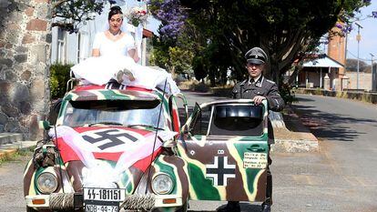 Una pareja junto a la carroza nupcial de una boda de temática nazi, celebrada el pasado 29 de abril, en Tlaxcala (México).