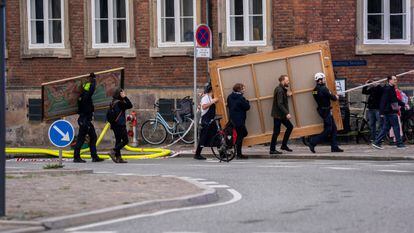 本周二，几个人从哥本哈根市中心燃烧的建筑中搬运画作。 