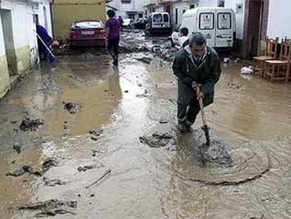 Un vecino de Rincón de la Victoria retiraba ayer agua y barro de una de las calles.