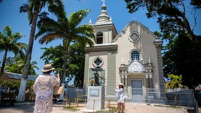 Dos mujeres toman fotografías a las afueras de una iglesia en Alagoas (Brasil), el pasado 23 de enero.