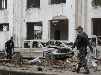 Policías, frente a vehículos dañados por el coche bomba.