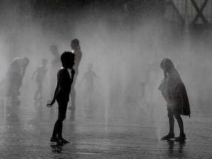 Varios niños se refrescan una de las zonas de Madrid Río el 19 de agosto de 2022, en plena ola de calor.