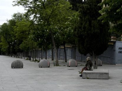 Una mujer espera sentada en un banco de la Cuesta de Moyano (Madrid). 