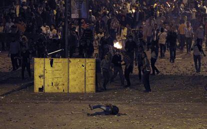 Un manifestante cae al suelo durante los enfrentamientos con la polic&iacute;a. La calle, llena de piedras, la munici&oacute;n delos manifestantes contra las fuerzas del orden. 