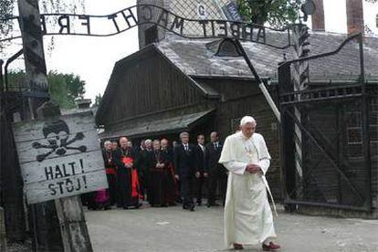 El Papa atraviesa la puerta del campo de concentración de Auschwitz, donde se lee en el letrero de la izquierda "¡Alto!" en polaco y en alemán.