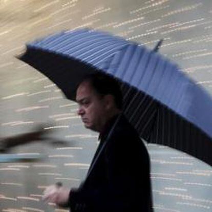 Un hombre se protegía ayer de la lluvia con un paraguas en el centro de Valencia