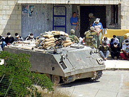 Varios soldados israelíes, ayer en Nablús, junto a un grupo de oficiales de la policía palestina detenidos.