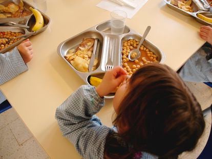 Unos niños comen en el comedor escolar.