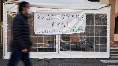 Un hombre camina delante de un cartel de protesta contra el cierre del consultorio médico de Arre en Navarra, el 13 de enero.