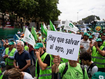 Un hombre con un cartel en el que se lee: 'Hay que salvar al agro ya!', durante una tractorada convocada por la Unión de Uniones de Agricultores y Ganaderos, frente al Ministerio de Agricultura, a 5 de julio de 2023, en Madrid (España).