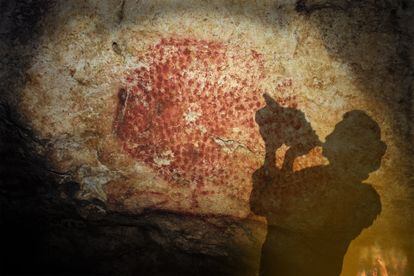 Proyección de la sombra de una persona mientras sopla la concha encontrada en la cueva decorada de Marsoulas, en Francia.